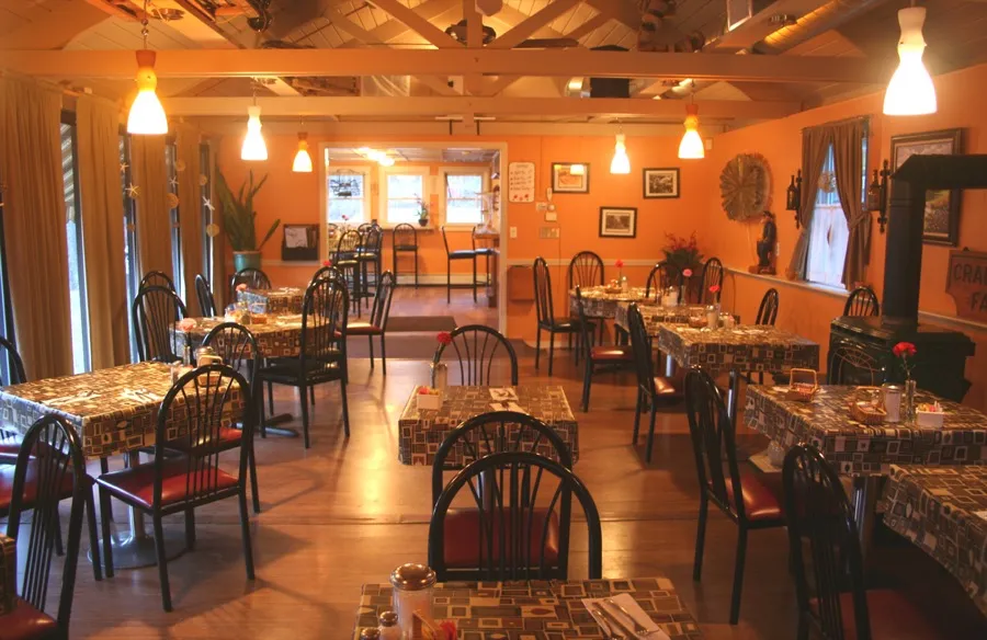 Crabapples dining room with warm lighting, wood floors and tables set for service