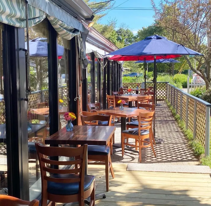 Shaded patio tables under a striped awning