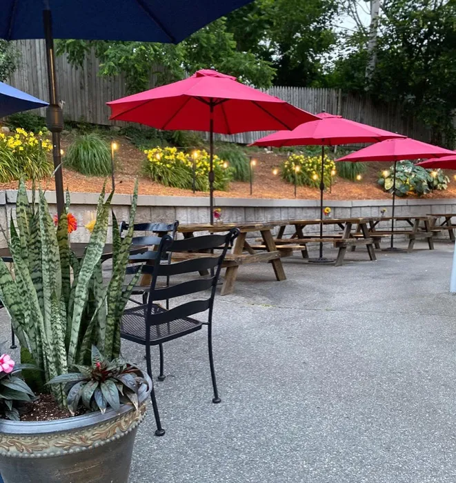 Outdoor patio with red umbrellas and picnic tables
